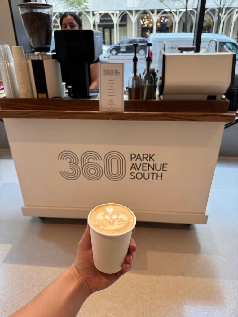 Coffee held in front of a custom 360 Park Avenue South cart