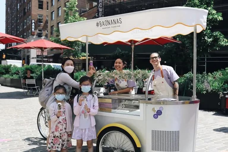 Guests and an attendant beside a Baonanas banana pudding cart