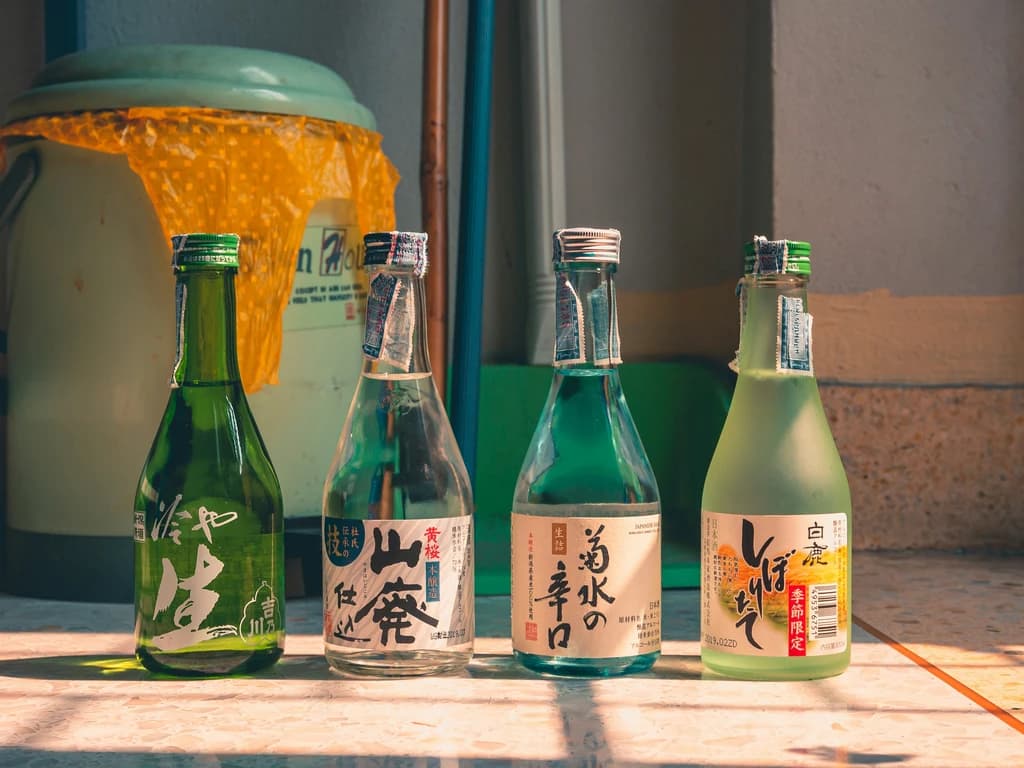 a table with 4 differnt saki bottles on it