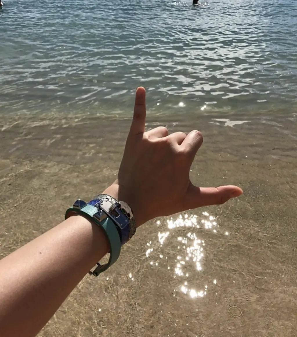 someone with bracelets on their wrist at the beach