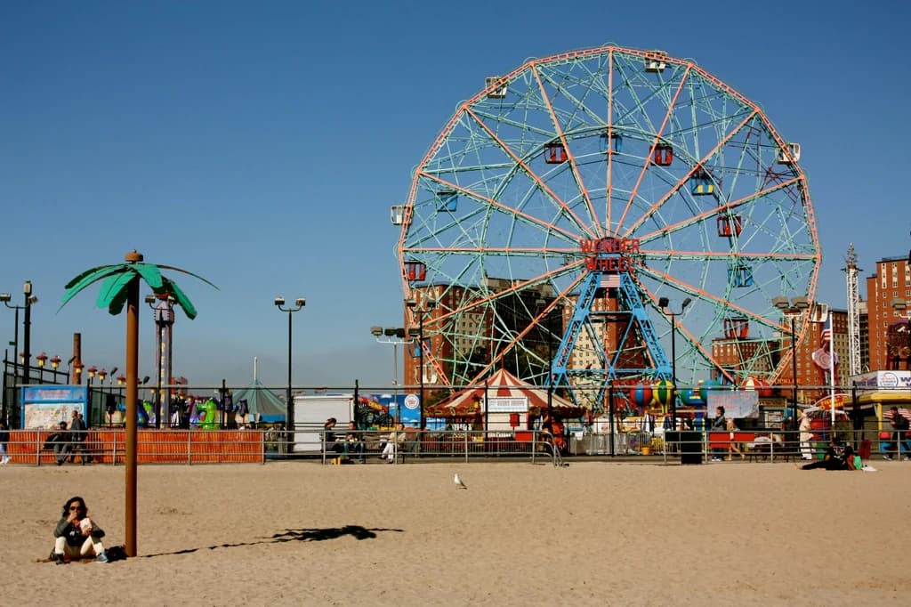 a view of coney island with their stands and rides in the background
