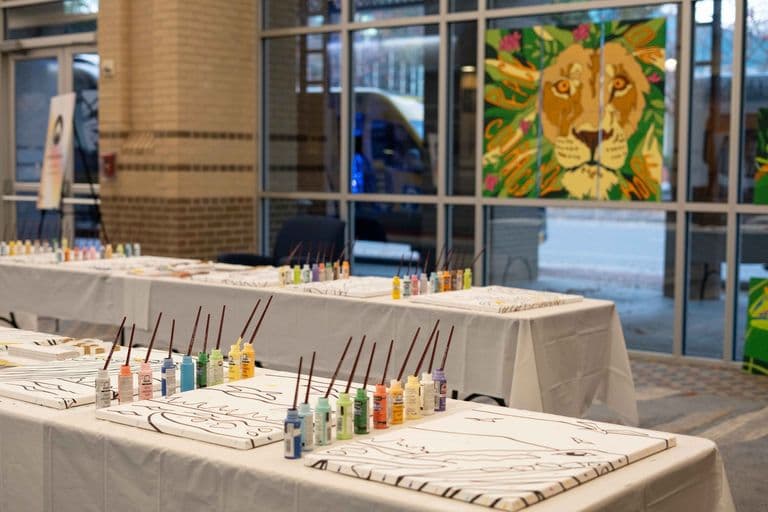 Art tables lined with canvases, brushes, and paints ready for a team volunteer painting activity.