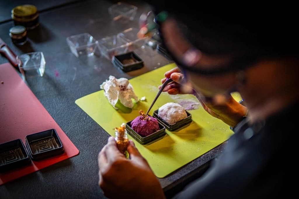 Close-up of a participant carefully decorating Japanese sweets, showcasing attention to detail and creativity.