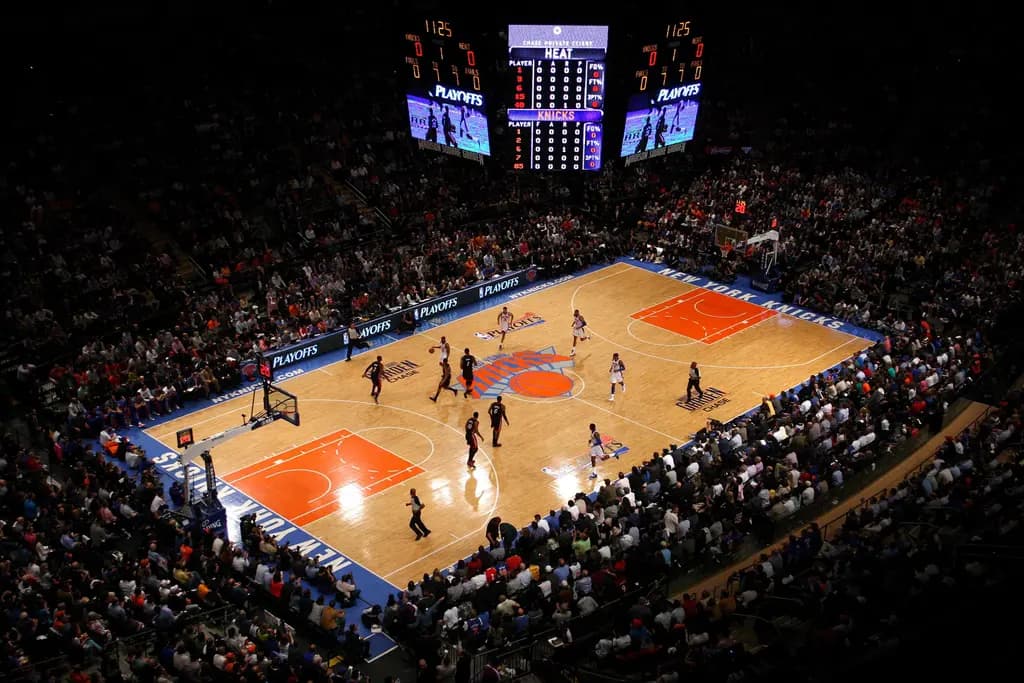 Crowd watching a Knicks game at Madison Square Garden from upper-level seating.