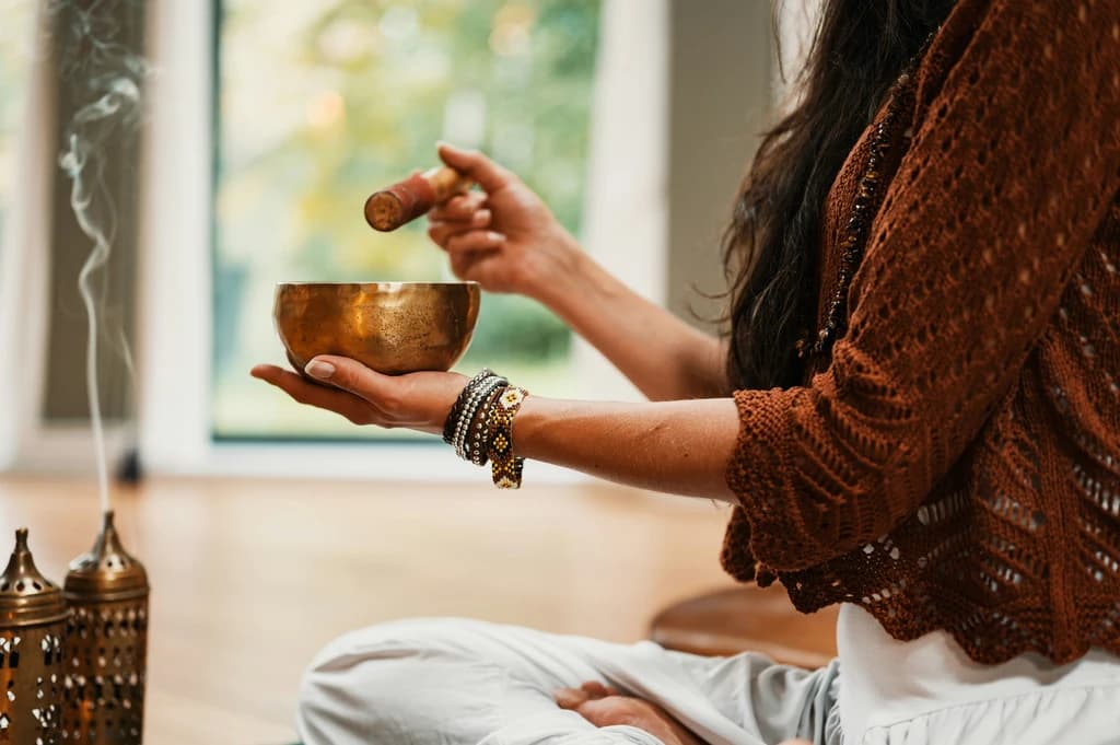 Close-up of a focused group meditating together on floor cushions in a peaceful setting.