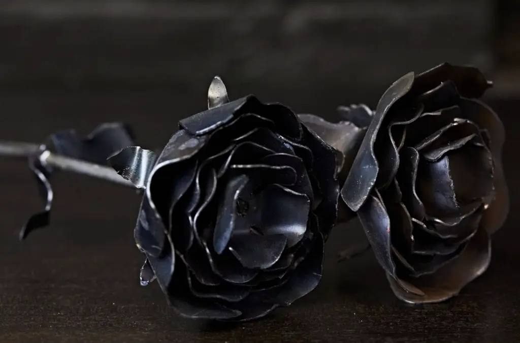 two flowers made out of metal laying on a table