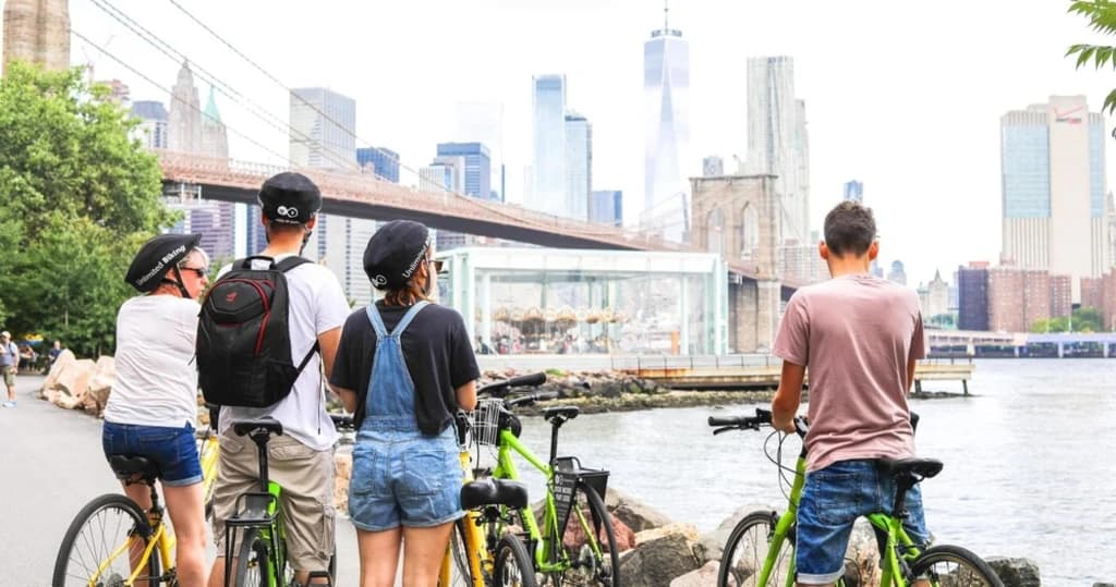 people on bikes looking at the new york skyline