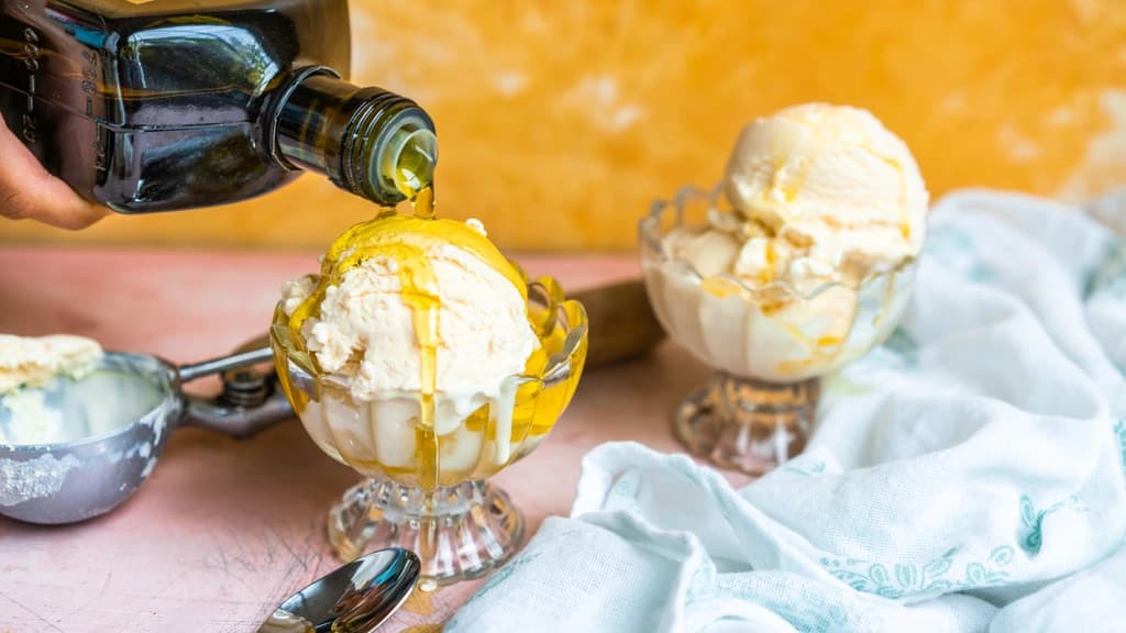 olive oil being poured on a bowl of ice cream