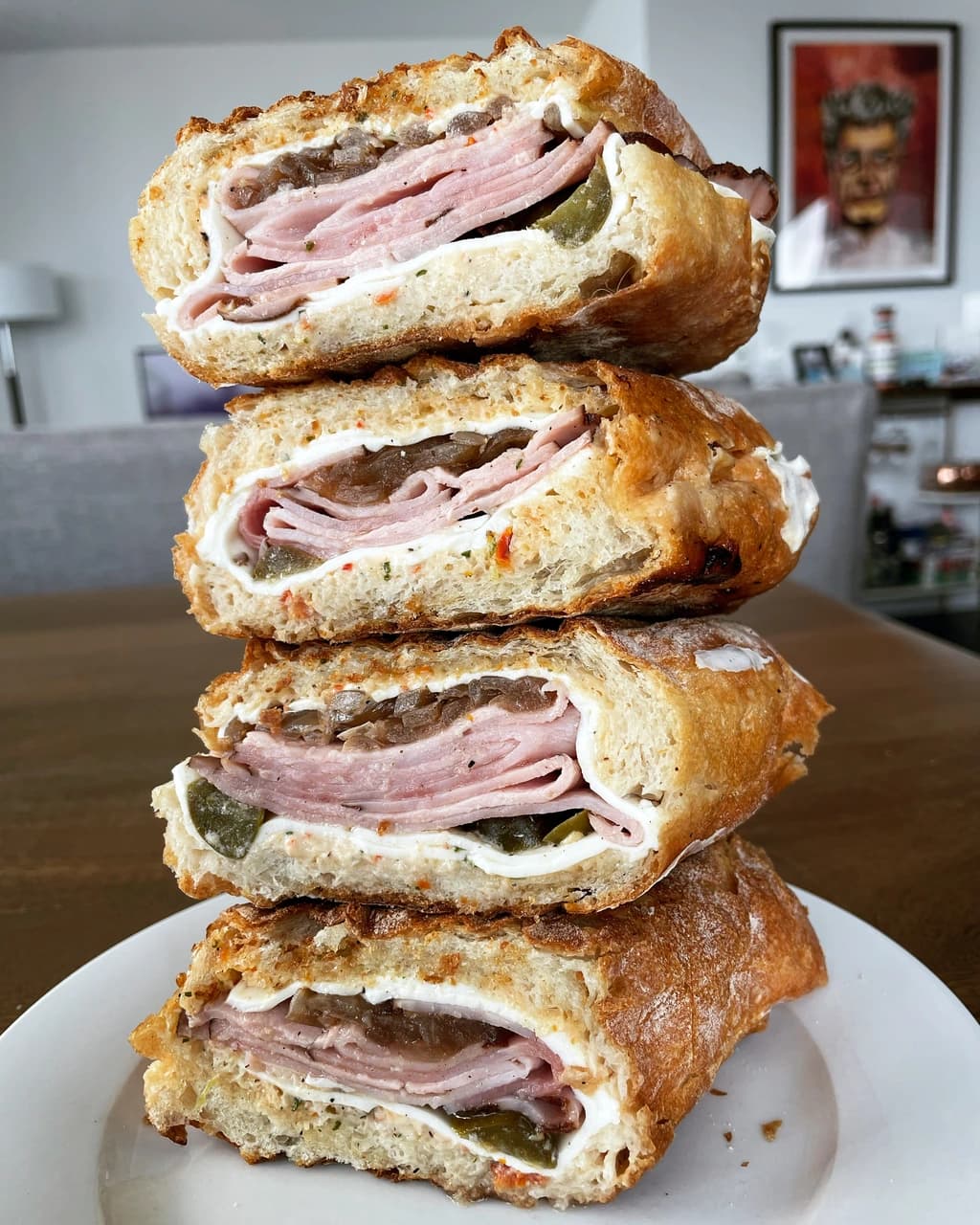A sandwich cut in half, showing layers of ham, cheese, and other ingredients inside a crunchy golden-brown bread.