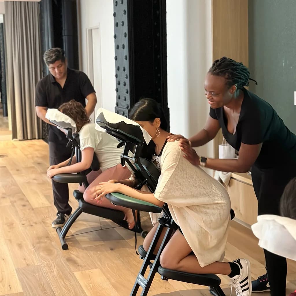 a row of people in chairs getting a massage
